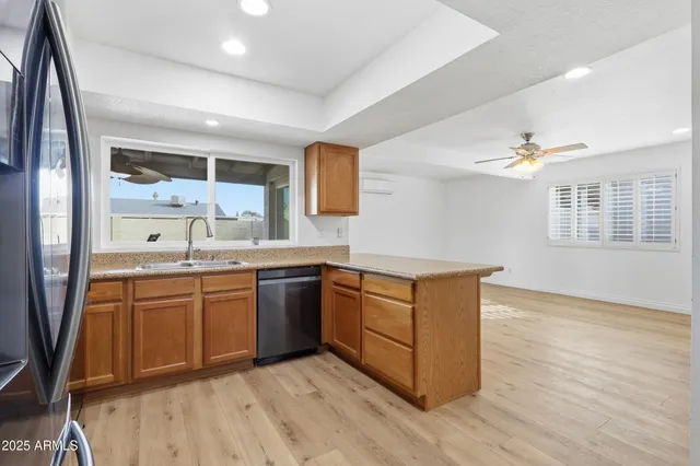a kitchen with stainless steel appliances granite countertop a sink cabinets and wooden floor