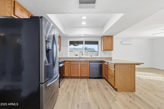 a large kitchen with a lot of counter space and wooden floor