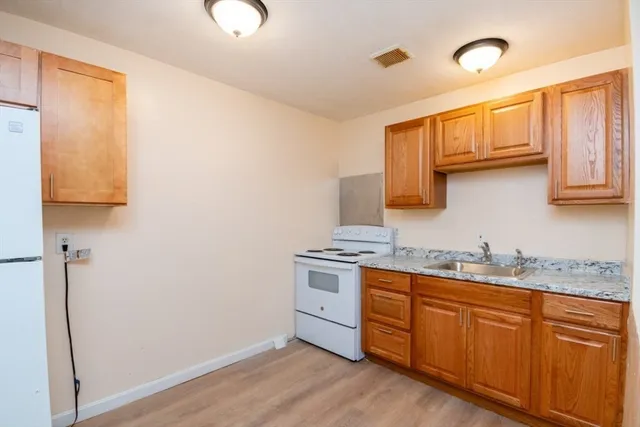 a kitchen with stainless steel appliances granite countertop a sink stove and refrigerator