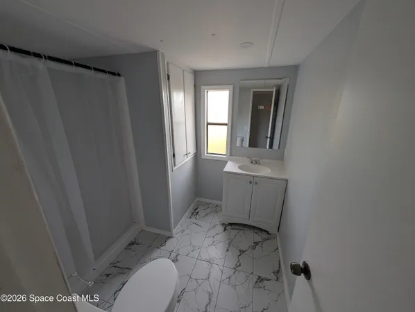 a bathroom with a sink toilet and window