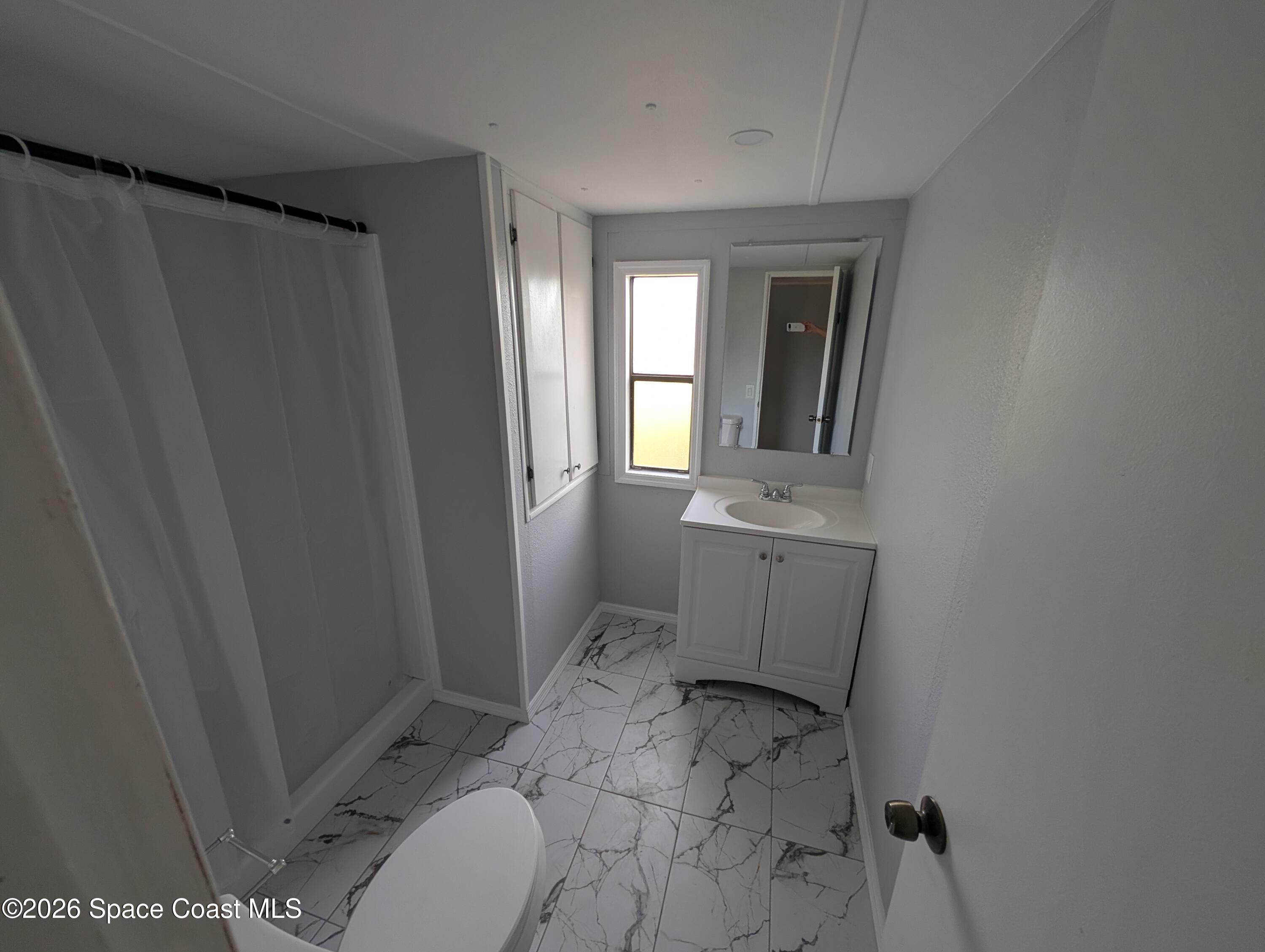 3314 Kittles Street Mims, FL 32754 - Photo 5 of 9 a bathroom with a sink toilet and window