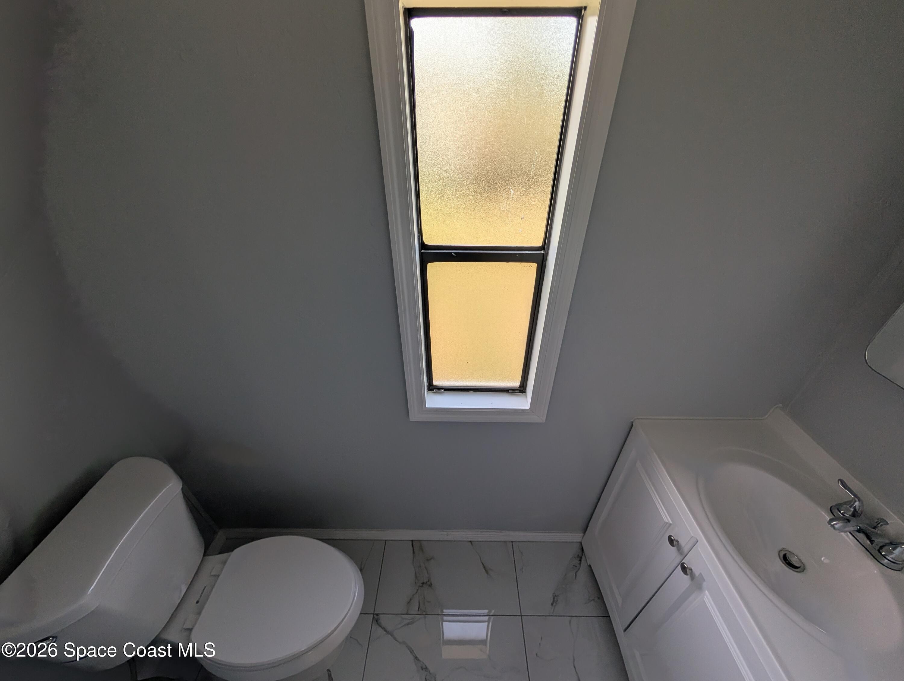 3314 Kittles Street Mims, FL 32754 - Photo 7 of 9 a white toilet sitting next to a bathroom sink