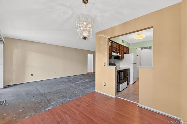 a view of a kitchen with a sink and dishwasher a refrigerator with wooden floor