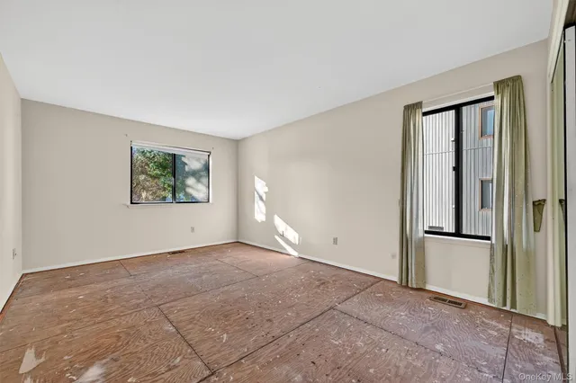 a spacious bedroom with a bed and a refrigerator