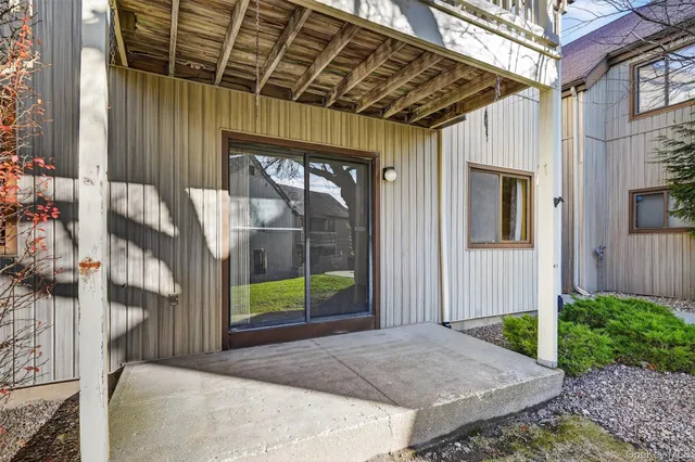 a tree in front of house with a yard