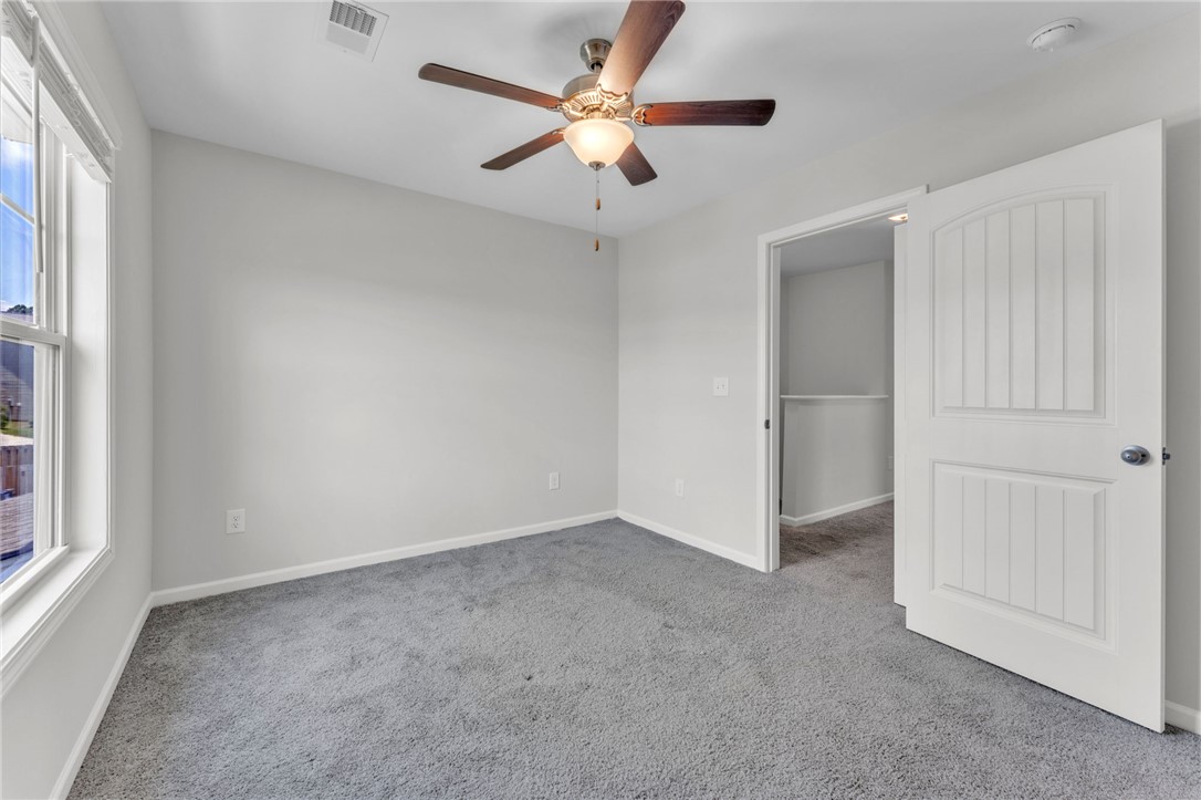 208 Samuel Street Pendleton, SC 29670 - Photo 18 of 32 A comfortable bedroom with a ceiling fan and plush gray carpeting.
