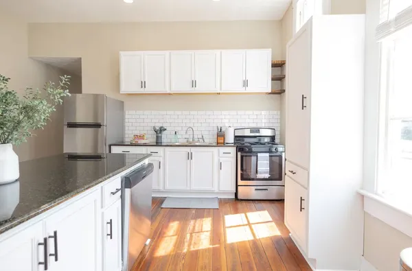a kitchen with stainless steel appliances granite countertop a sink and a stove