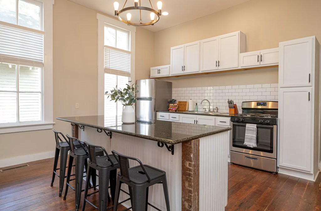 1300 18th Street Columbus, GA 31901 - Photo 23 of 38 a kitchen with stainless steel appliances granite countertop a sink a stove and chairs