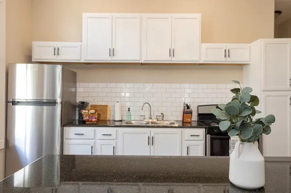 a kitchen with stainless steel appliances a stove a sink and a window