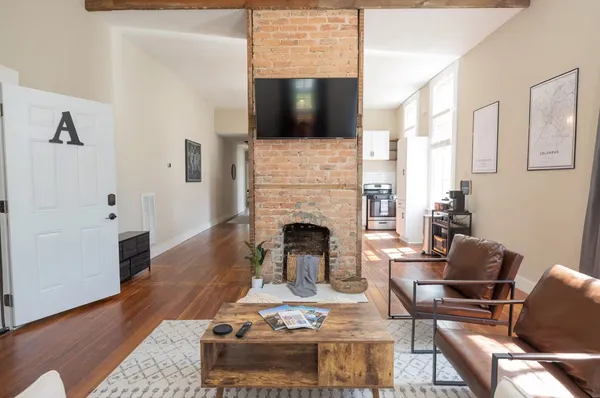 a living room with furniture a fireplace and a flat screen tv