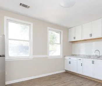 a kitchen with granite countertop white cabinets and white appliances