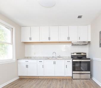 1300 18th Street Columbus, GA 31901 - Photo 33 of 38 a kitchen with granite countertop white cabinets and white appliances