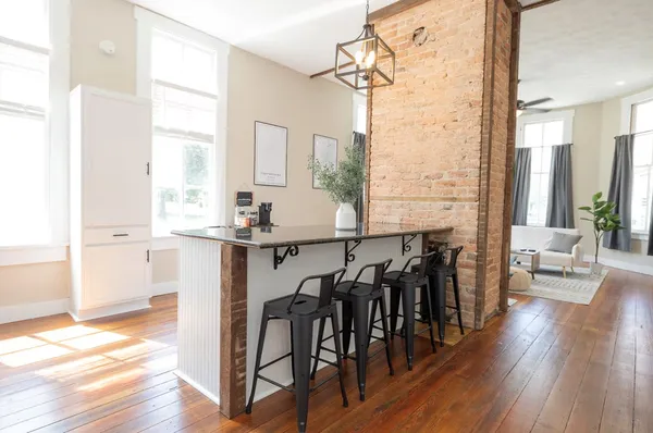 a view of a a dining room with furniture window and wooden floor