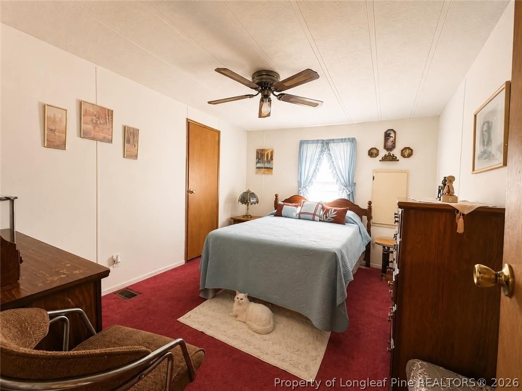 4435 Tartt's Mill Road Wilson, NC 27893 - Photo 13 of 23 a bedroom with a bed and wooden floor