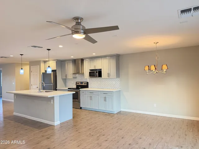 a view of a kitchen with kitchen island a stove a sink and a refrigerator