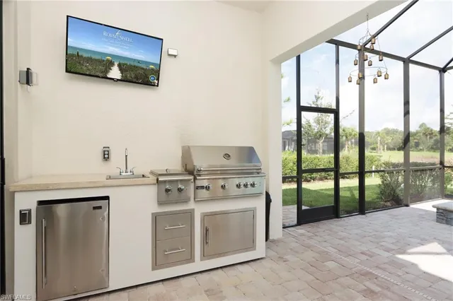 a kitchen with stainless steel appliances a stove and a view of living room