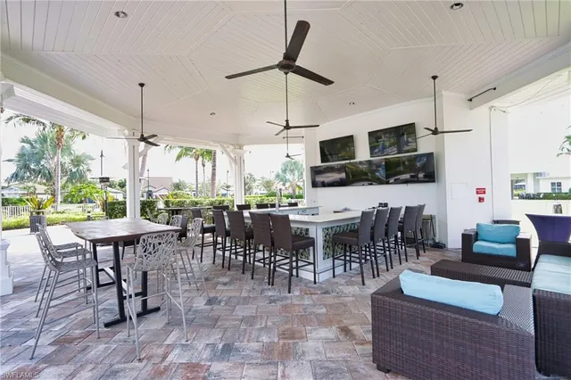 a outdoor space with lots of tables a large window and furniture