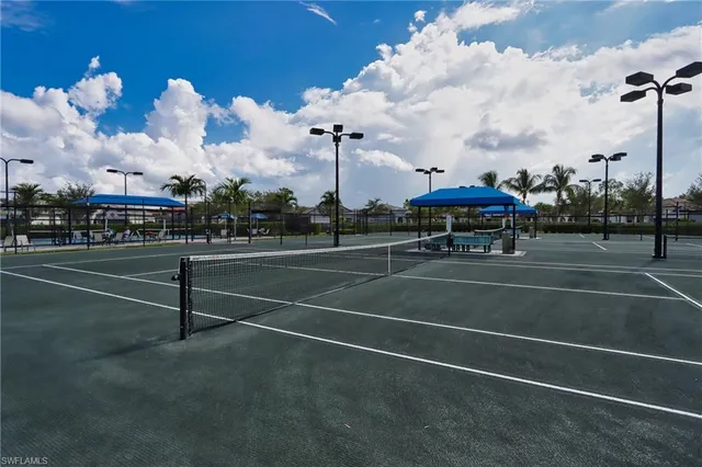 a view of a tennis ground with a fountain