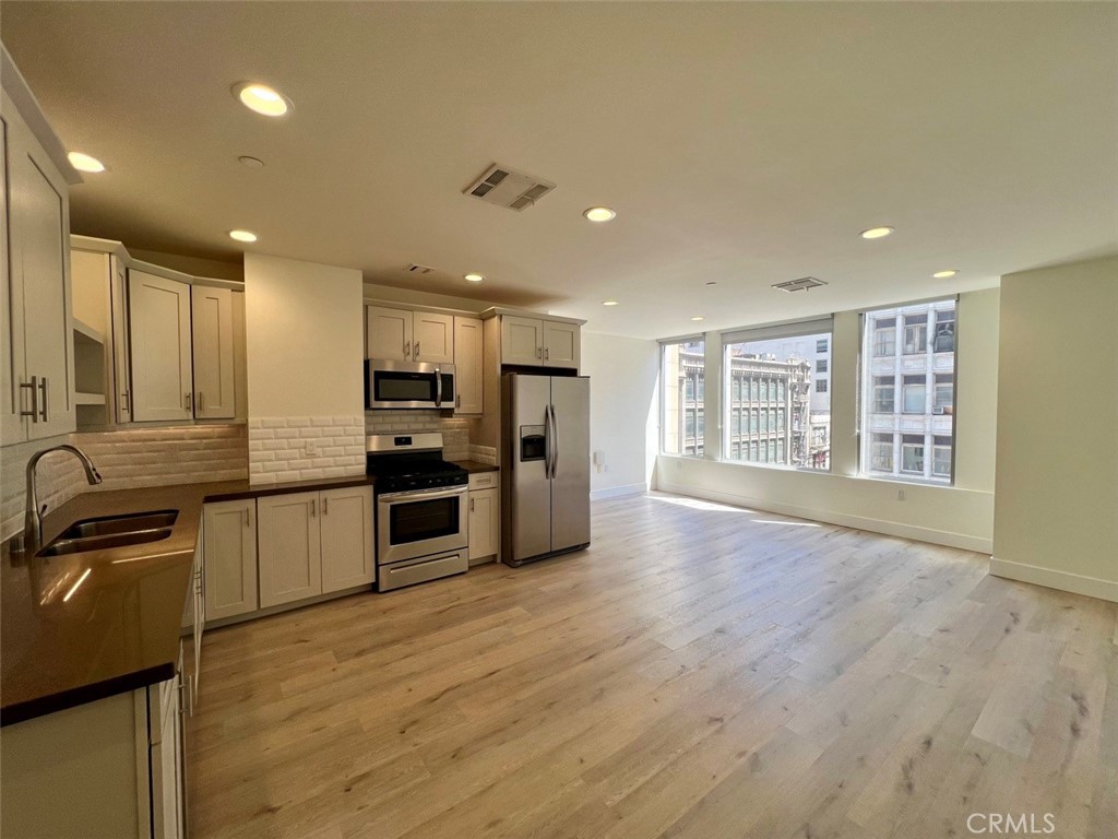 314 6th, Unit 506 Los Angeles, CA 90014 - Photo 3 of 12 a view of kitchen with stainless steel appliances granite countertop a stove top oven a sink and a refrigerator