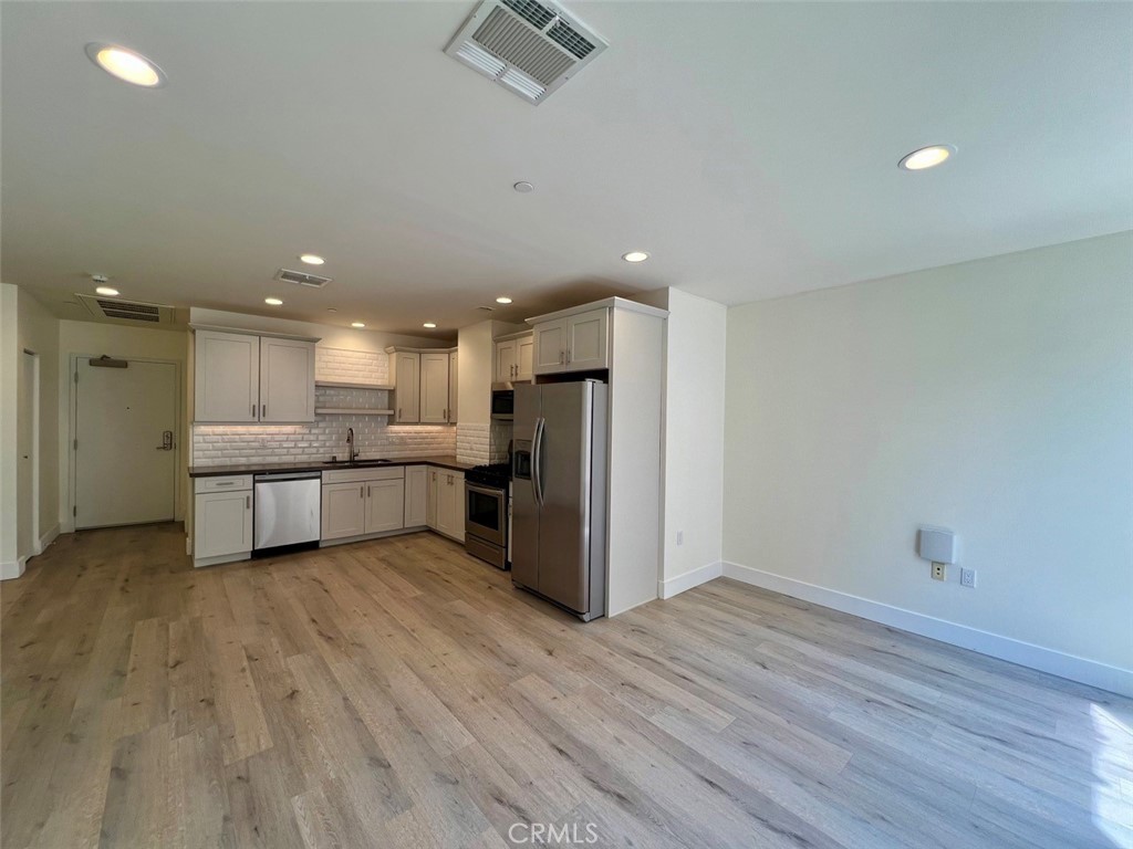 314 6th, Unit 506 Los Angeles, CA 90014 - Photo 4 of 12 a view of kitchen with stainless steel appliances refrigerator oven and white cabinets with wooden floor