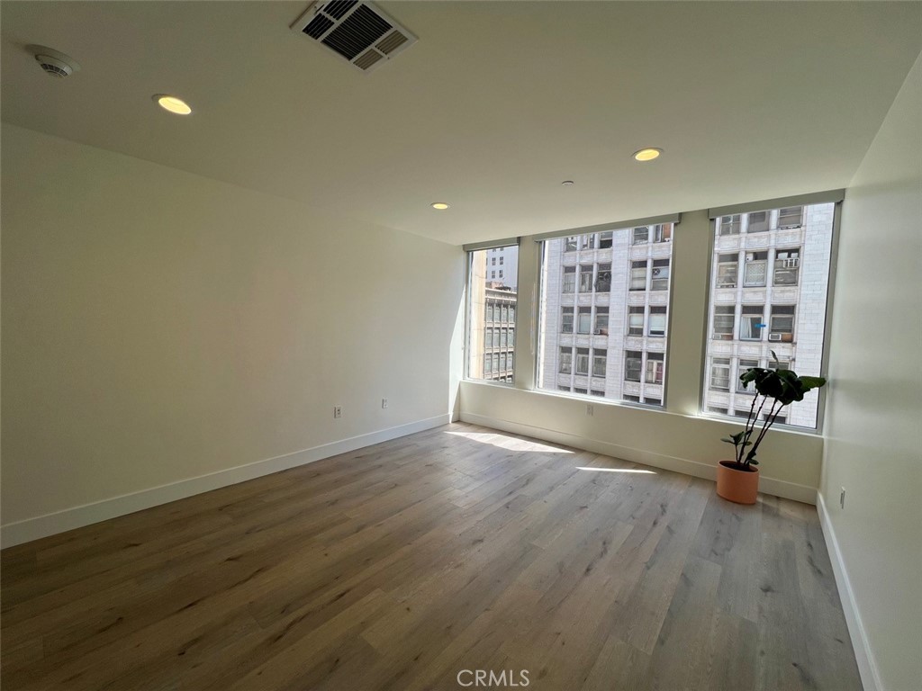 314 6th, Unit 506 Los Angeles, CA 90014 - Photo 7 of 12 an empty room with hard wood floors and windows