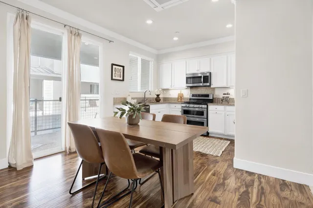 a kitchen with stainless steel appliances a dining table and chairs