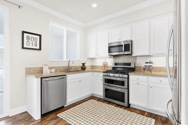 a kitchen with granite countertop a stove top oven and cabinets