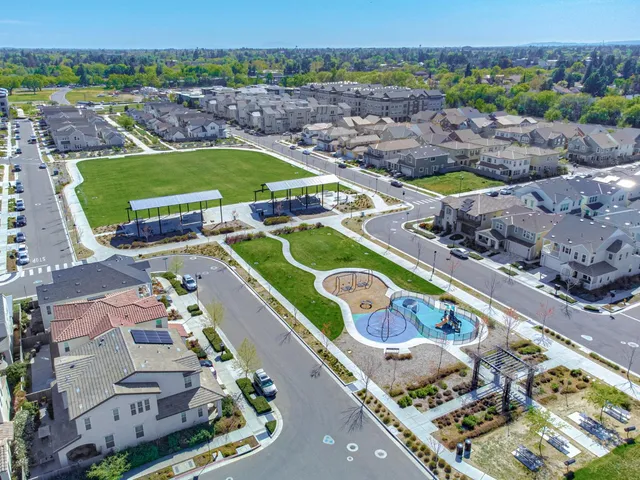 an aerial view of a swimming pool a yard and mountain view in back