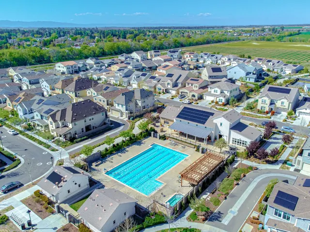an aerial view of a city with lots of residential buildings and mountain view in back