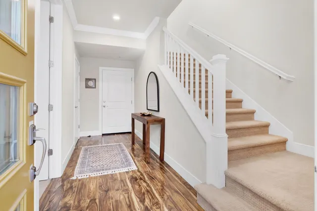 a view of a hallway with wooden floor and staircase