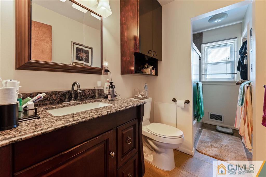 10 Monaghan Road Edison, NJ 08817 - Photo 19 of 23 a bathroom with a granite countertop sink a toilet and mirror