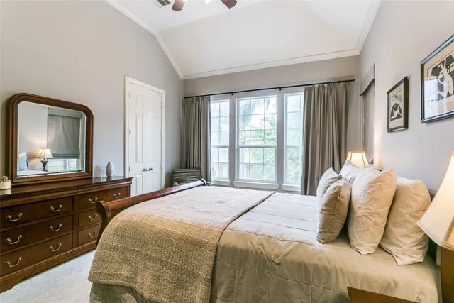 a bedroom with a bed and a mirror on dresser