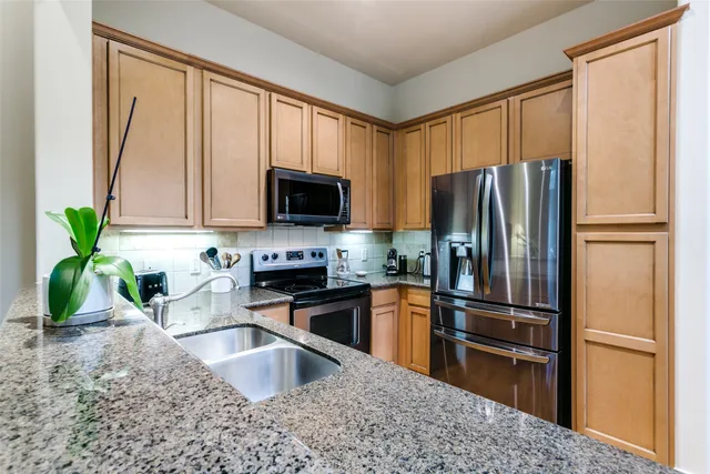 a kitchen with granite countertop a refrigerator and a sink
