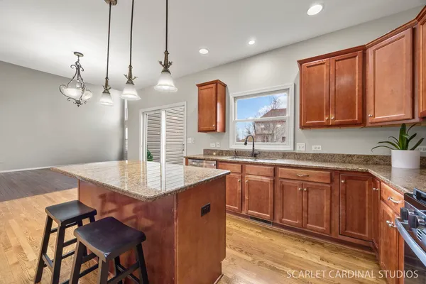 a kitchen with stainless steel appliances granite countertop a sink and dishwasher with wooden cabinets