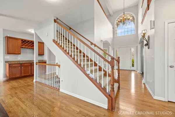 a view of staircase with lots of frames on wall and wooden floor