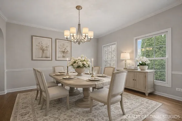 a view of a dining room with furniture a chandelier and wooden floor