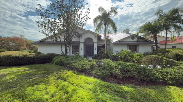 a front view of a house with a garden and trees