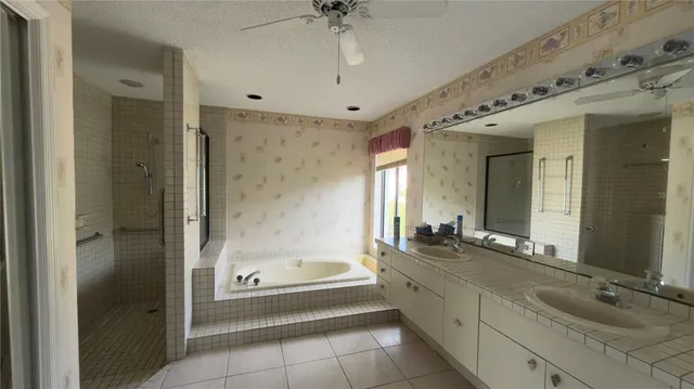 a bathroom with a bathtub shower sink and mirror