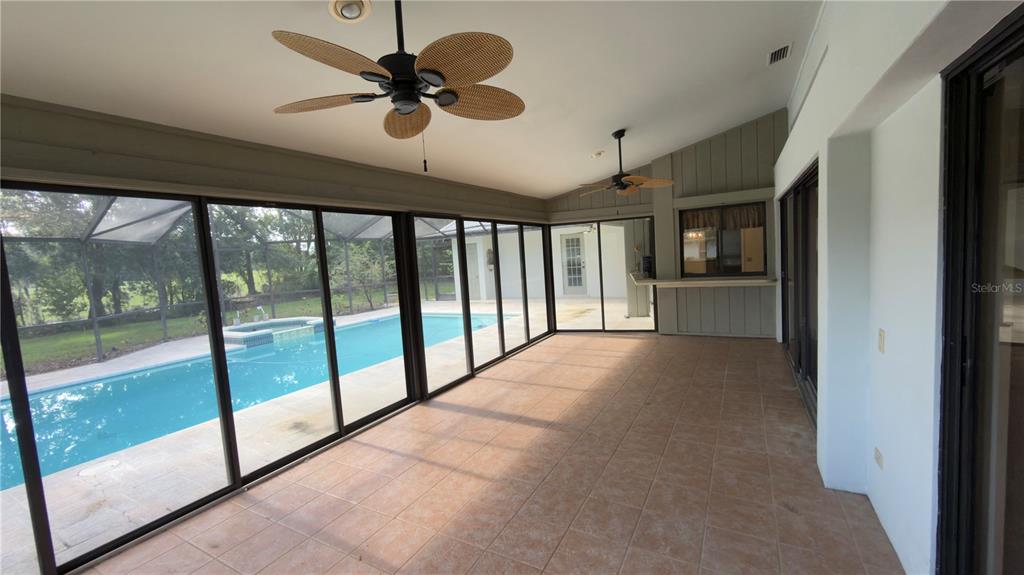 5040 Pinelake Road Wesley Chapel, FL 33543 - Photo 17 of 38 a view of n empty room with a ceiling fan and windows