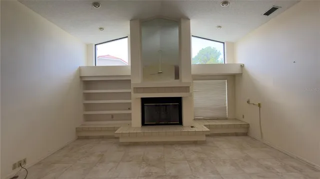 a living room with furniture a fireplace and a window