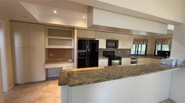 a kitchen with kitchen island a sink stainless steel appliances and a counter top space