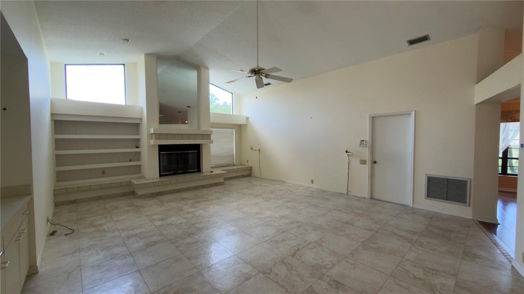 5040 Pinelake Road Wesley Chapel, FL 33543 - Photo 23 of 38 an empty room with a fireplace and fan