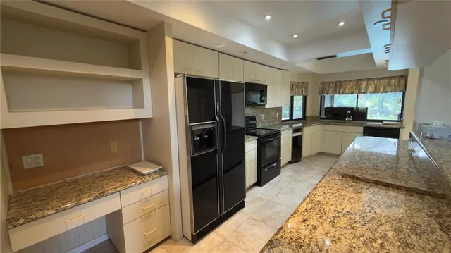 a kitchen with granite countertop a refrigerator and a stove
