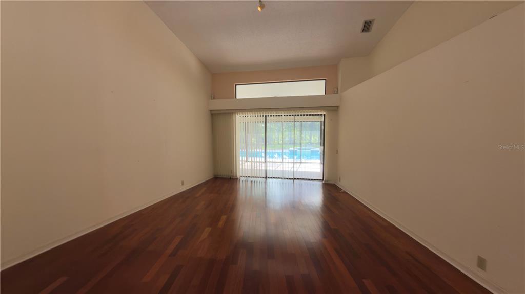 5040 Pinelake Road Wesley Chapel, FL 33543 - Photo 7 of 38 a view of an empty room with wooden floor and a window