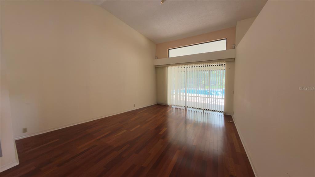 5040 Pinelake Road Wesley Chapel, FL 33543 - Photo 8 of 38 an empty room with wooden floor and windows