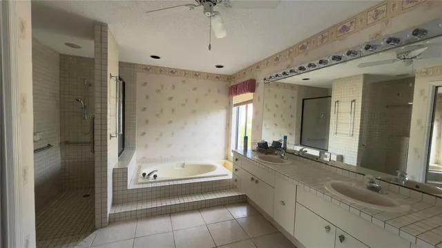 a spacious bathroom with a granite countertop tub sink and mirror