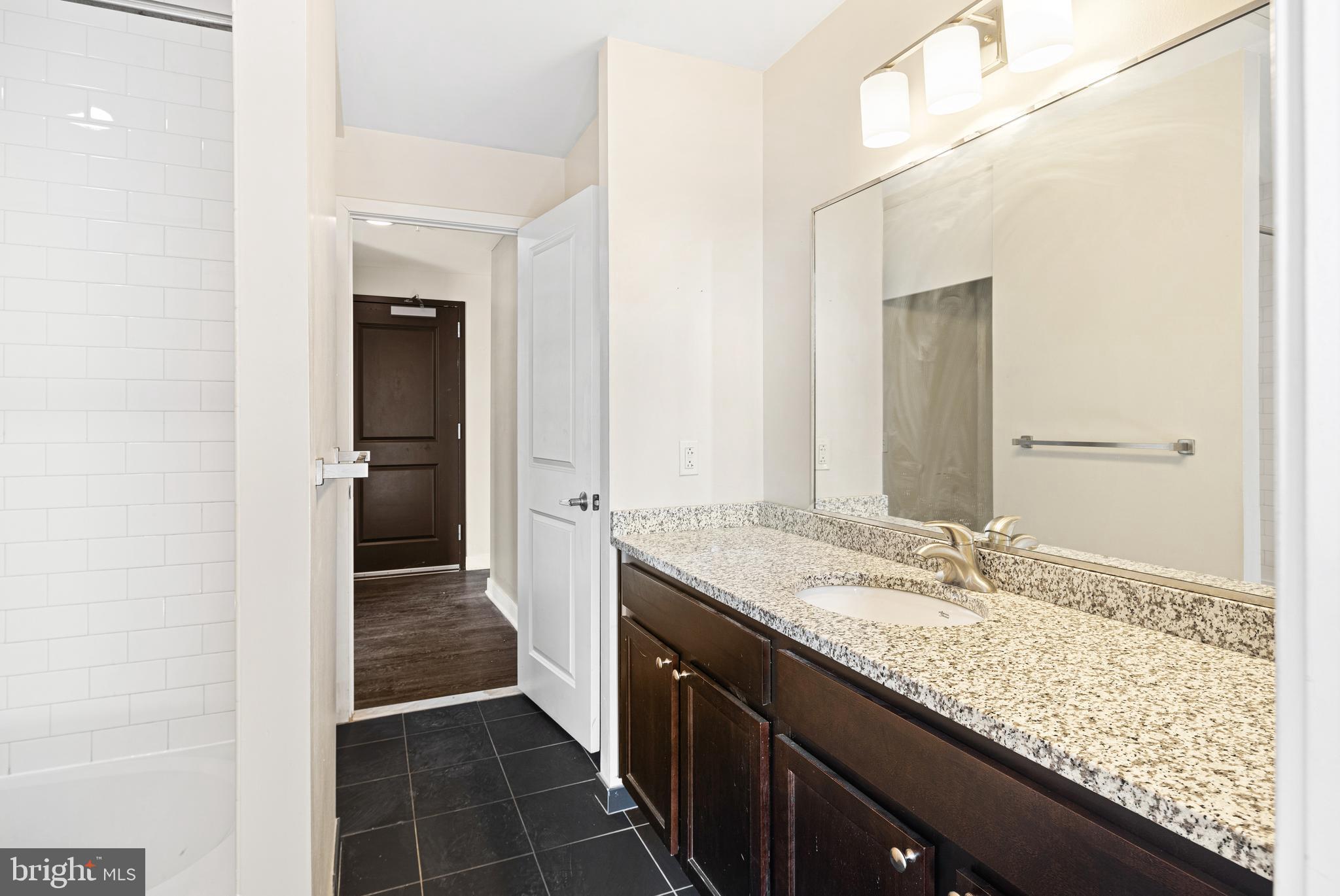523 North Broad Street, Unit P1 Philadelphia, PA 19123 - Photo 12 of 37 a bathroom with a granite countertop sink and a mirror