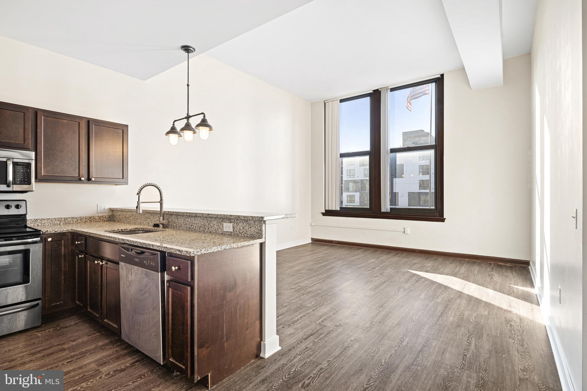 523 North Broad Street, Unit P1 Philadelphia, PA 19123 - Photo 14 of 37 a kitchen with stainless steel appliances granite countertop a sink and wooden floors