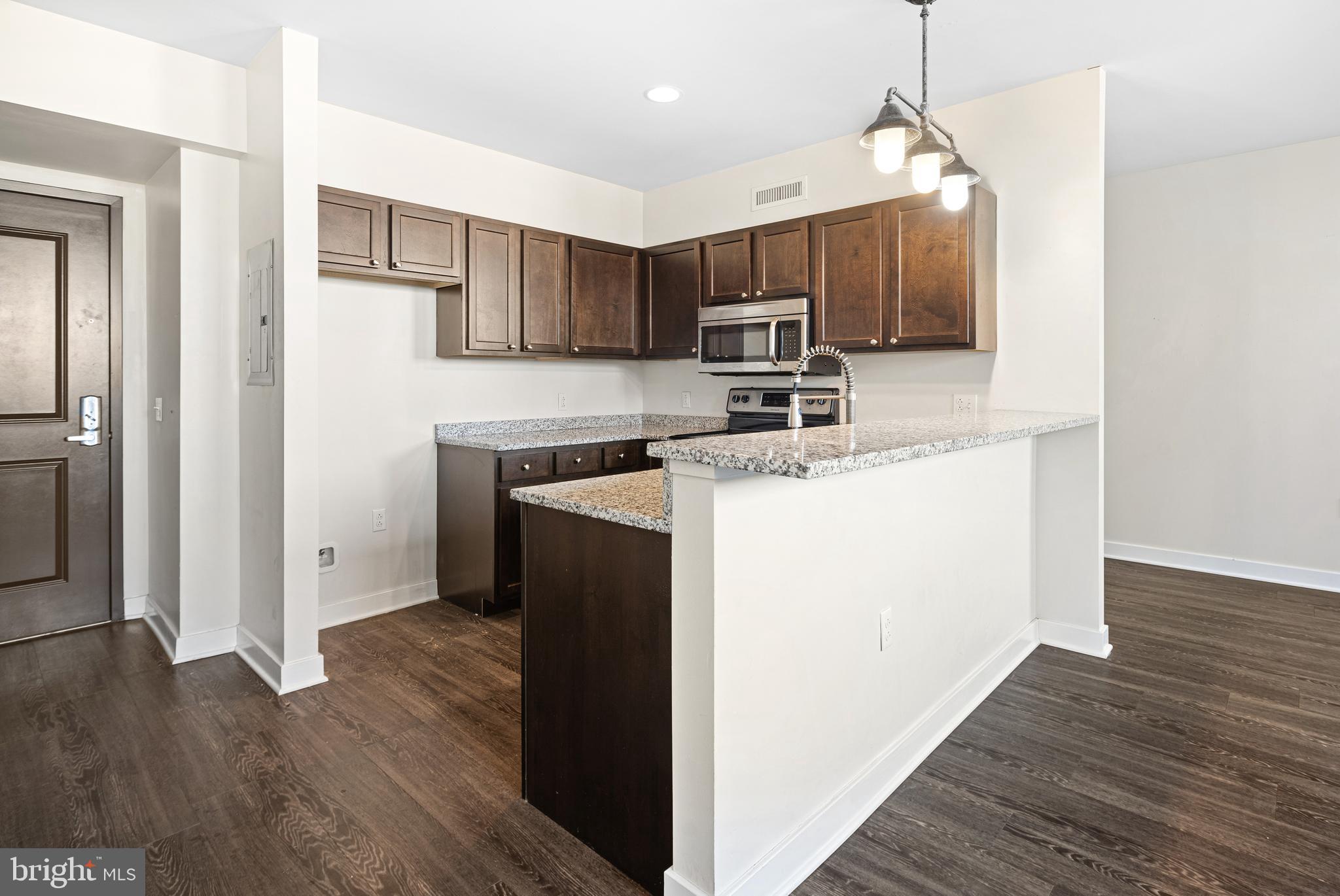 523 North Broad Street, Unit P1 Philadelphia, PA 19123 - Photo 27 of 37 a kitchen with kitchen island a sink stainless steel appliances and wooden floor