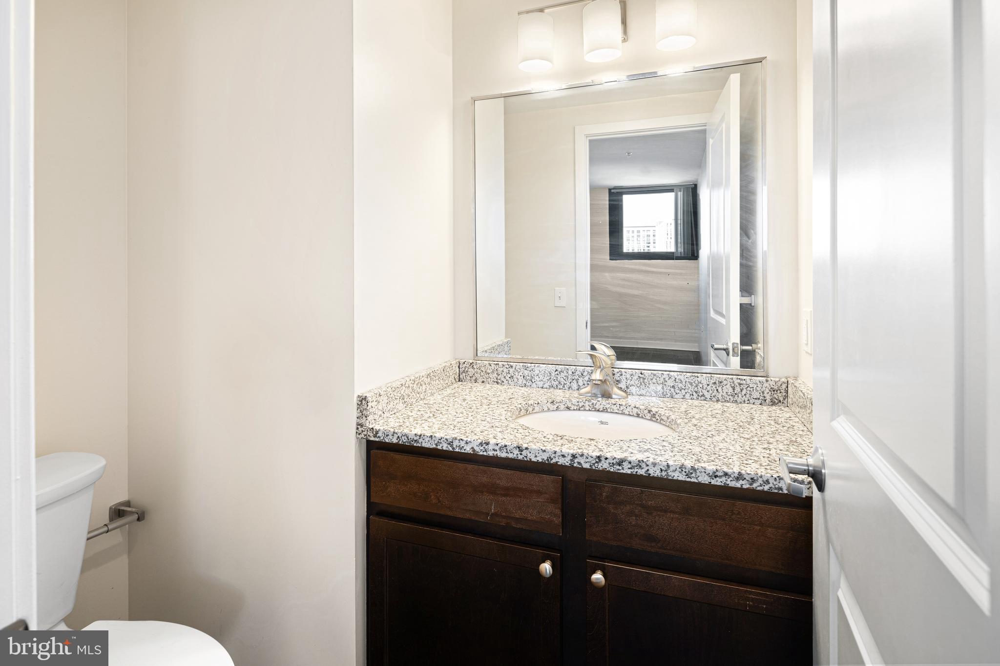 523 North Broad Street, Unit P1 Philadelphia, PA 19123 - Photo 29 of 37 a bathroom with a granite countertop sink and a mirror